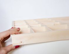 a woman's hand is holding a wooden drawer