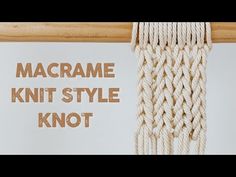 the macrame knit style knot is hanging from a wooden pole