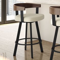 two modern bar stools with wood and fabric upholstered seats in front of a window