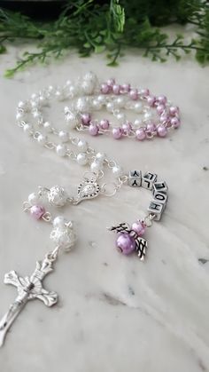 "A 2 color Personalized rosary made with glass pearl beads, glory beads in different colors covered with silver plated bead caps, a Virgin Mary centerpiece, crucifix, and metallic acrylic cube letters This rosary is a perfect gift for a baptism, confirmation, first communion, baby shower, graduations, Confirmations, weddings or any other occasion This rosary comes in 2 different colors of your choice The colors on the rosary goes pearl, the color you pick, pearl, the color you pick, pearl You ca Quinceanera Bible, Bible And Rosary, Cube Letters, Personalized Rosary, Christening Ideas, The Rosary, Team Board, Personalized Photo Gifts, Baptism Gifts