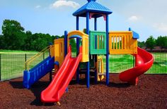 there is a colorful playground set in the dirt