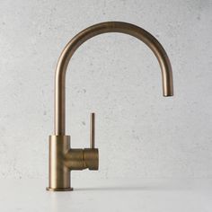 a brass faucet on a white counter top