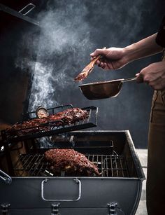 a person cooking food on top of a bbq grill with tongs and spatula