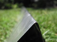 a close up view of the corner of a metal object in the middle of some grass