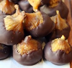 chocolate covered fruit sitting on top of a wooden cutting board