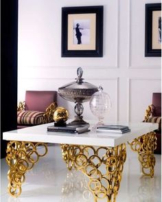 a living room with white walls and gold accents on the coffee table in front of two couches