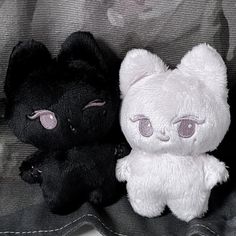 two black and white stuffed animals sitting next to each other