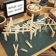 wooden clothes pins are arranged on a table with a sign that says what can you build?