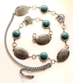 This is a beautiful handmade silver western Concho chain belt. Man made Silver scalloped slotted oval  Conchos, Howling wolf and feather  Concho and and round manmade turquoise Conchos. This chain belt has  Lobster clasp and small man made silver  feather at end of extension chain. Large Concho is 1-3/4" oval,  Round Conchos are right around 1" and wolf Concho is 1". This is a Unique style sure to be one of a kind. Comes in 2 sizes which are measured end to end of Conchos and then total length. Adjustable Silver Bohemian Belt, Adjustable Silver Belt, Bohemian Silver Adjustable Belt, Adjustable Silver Belt For Festival, Silver Concho Belts For Festivals, Silver Concho Belt For Festival, Festival Silver Concho Belt, Festival Silver Belt With Concho Details, Silver Bohemian Adjustable Belt Buckles