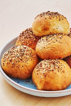 a white plate topped with rolls covered in sesame seeds