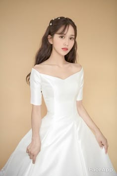 a woman in a white wedding dress posing for the camera with her hands on her hips