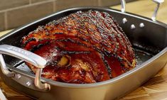 a roasting pan filled with meat on top of a wooden table