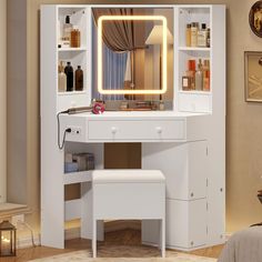 a white dressing table with a lighted mirror and stool next to it in a bedroom