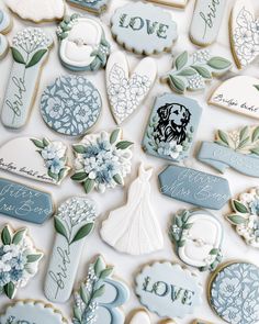 wedding cookies are arranged on a table with blue and white decorations, such as flowers