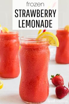 strawberry lemonade smoothie in mason jars with strawberries and lemons on the side