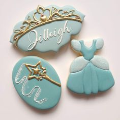 three cookies decorated with royal blue icing and gold trimmings, one for a princess