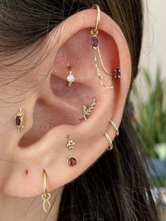 an ear with several different types of piercings on it's sides and one is attached to the side of the ear