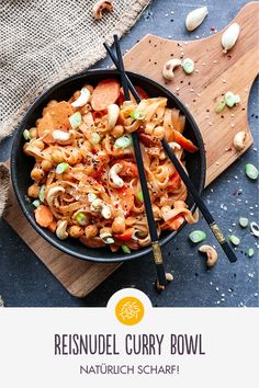 a bowl filled with noodles and vegetables on top of a cutting board next to chopsticks