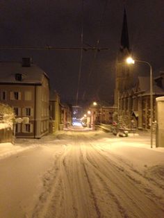 a city street is covered in snow at night