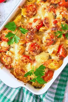 a casserole dish with tomatoes, sausage and parsley