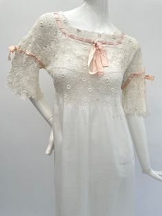 This very pretty and fine quality antique Edwardian full-length night gown is made from white cotton with an Irish Crochet bodice. It retains its original pink silk ribbons at the front, back and on the sleeves and it has an embroidered monogram to the front. The ribbons can be adjusted and the ends can be tied in a bow or left to hang loose. This is loose cut from the Irish Crochet section of the bodice downwards so it will fit a variety of sizes.  When laid flat it measures: From underarm to u Feminine Victorian Dress For Daywear, Feminine Victorian Dress With Lace Trim For Daywear, Victorian Peasant, Shirt Under Dress, Linen Nightgown, Cotton Night Dress, Crochet Bodice, Victorian Nightgown, Long Nightdress