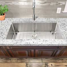 a stainless steel kitchen sink with granite counter tops