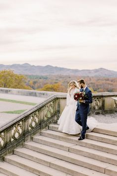 a bride and groom walking up some stairs