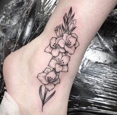 a black and white flower tattoo on the foot