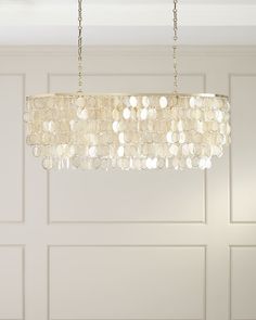 a chandelier hanging from a ceiling in a room with white paneled walls