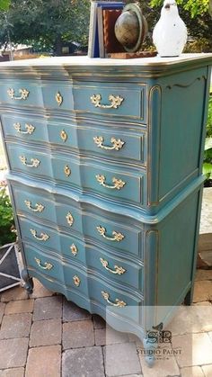 an old dresser is painted blue and gold