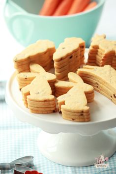 some cookies are on a plate with carrots in the background