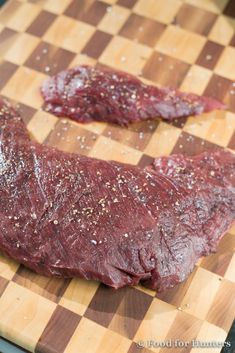 a piece of meat sitting on top of a wooden cutting board