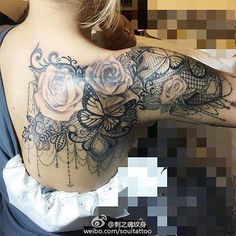 the back of a woman's shoulder with roses and butterflies on it