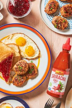 an assortment of breakfast foods on plates with condiments