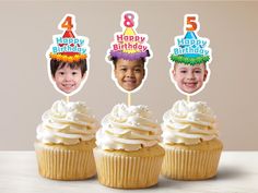 three cupcakes with candles on top of them and the faces of two children