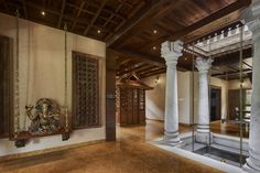 an ornately decorated entry way with columns and mirrors on the wall, in front of a wooden door