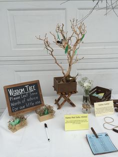 a table with several items on it including a sign, pen and tree branch decoration