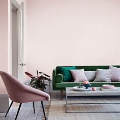 a living room with pink walls and green furniture