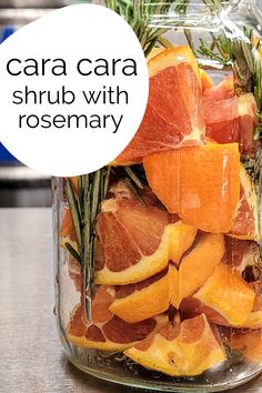 a jar filled with oranges and rosemary