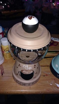 an old fashioned coffee grinder sitting on top of a wooden table