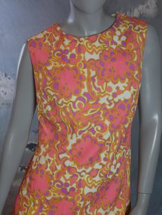 This 1960s sheath dress has a stunning abstract floral pattern in pink, purple, and pale chartreuse on a cream background. The sleeveless summer dress is crafted from an accordion textured viscose fabric. Note that the stitched hemline has been let out at some point, and so you can leave it as is or hem it to your preferred length (see pix). Bust = 38 inches (96cm) Waist = 36 inches (91.44cm) Hips = 42 inches (106.68cm) Dress Length = 41 inches (104.14cm) Back Zipper = 20 inches (50.8cm) Size: 1 Pink Sleeveless Dress With Retro Print, Fitted Sleeveless Dress With Vintage Pattern, Pale Chartreuse, Mad Men Dresses, Formal Cocktail Party, Sleeveless Summer Dress, Vintage Midi Dresses, European Dress, Sleeveless Dress Summer