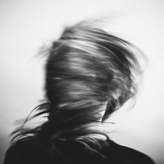 a blurry photo of a woman's head with her hair blowing in the wind