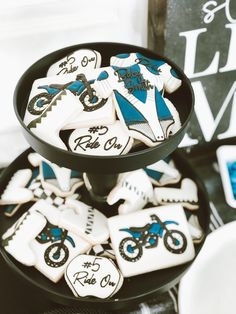 decorated cookies in the shape of motorbikes are displayed on a black platter