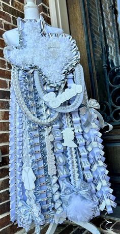 a dress made out of paper and other items on the side of a brick building