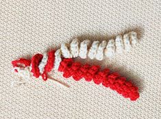 two crocheted red and white objects laying on top of each other in the shape of letters