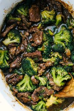 beef and broccoli in a pot with a wooden spoon