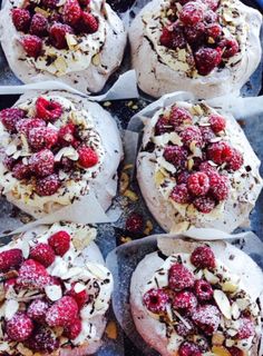 several muffins covered in whipped cream and raspberries