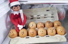 an elf is sitting in the fridge with eggs