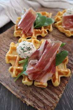 waffles topped with bacon, cheese and greens on a cutting board