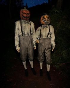 two scarecrows are walking down a path at night with their heads turned to look like they're scary